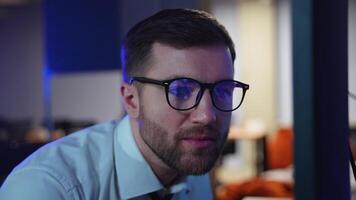 Trader investor broker in eyeglasses and formal wear working with pc while sitting in his office in front of computer screens with trading charts video