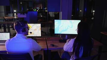 Two air traffic controllers track on the map route of plane video