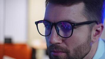 Cryptocurrency stock market trader wearing glasses looking at computer screen with trading charts reflecting in eyeglasses watching stock trading market financial data growth concept video