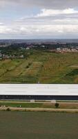 Contemporary business building. View from above on a modern industrial building surrounded by natural fields. Aerial view. Motion camera forward. Vertical video