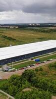 Modern industrial complex in the rural place. View from the air on commercial building in summer time. Aerial view. Vertical video
