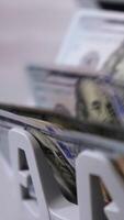Money counting machine. Banknote counter are counting hundred dollar bills. Close-up Vertical video
