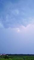 Real flashes of lightning on the blue sky background. The blue sky changes its color into orange after the bright lightning. Vertical video