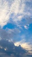 Amazing light clouds appearing in the sky. Timelapse of quick cloud transformation. Low angle view. Vertical video