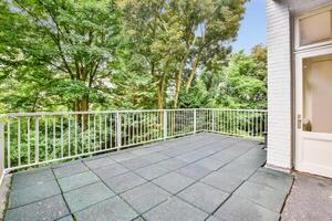 A balcony with a railing and trees in the background photo