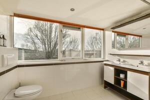 A bathroom with a sink, toilet and a window photo