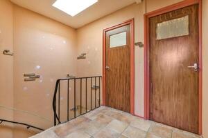 A hallway with a door and stairs photo