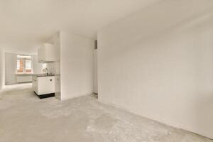 An empty room with white walls and a sink photo