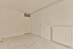 An empty room with a radiator and a door photo