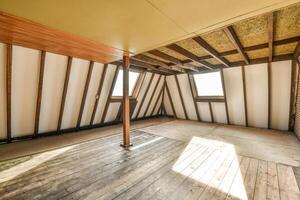 An empty attic with wood floors and a skylight photo