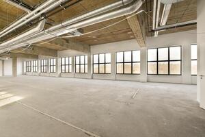 An empty office space with large windows and lots of light photo