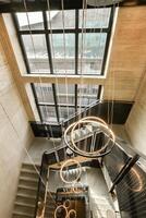 A staircase with a circular light fixture hanging from the ceiling photo
