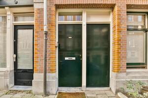 A brick building with green doors and windows photo