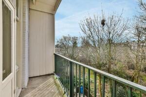 A balcony with a railing and a view of the trees photo