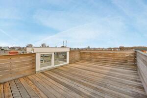 A wooden deck with a window and a view of the city photo