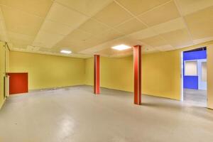 An empty room with yellow walls and red pillars photo