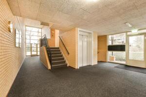An empty hallway with a staircase and a door photo