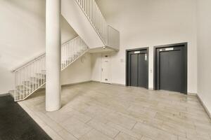 An empty hallway with two elevators and stairs photo