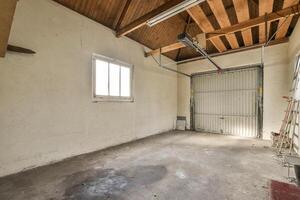 An empty garage with a ceiling fan and a window photo
