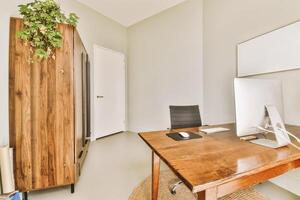 A wooden desk with a computer and a plant photo