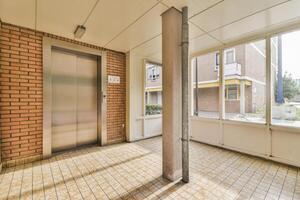 An empty hallway with a brick wall and a door photo