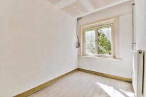 An empty room with a window and a radiator photo