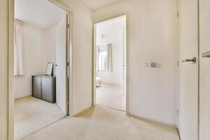 A hallway with a door and a cabinet photo