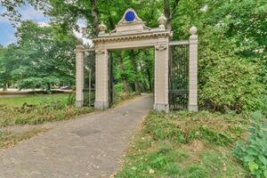 The entrance to a park with a gate and trees photo