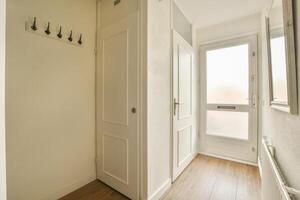 A hallway with a door and a coat rack photo