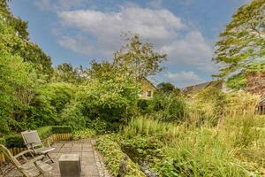 A garden with a bench and a pond in the background photo