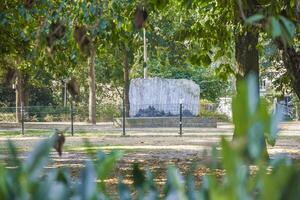 A statue in the middle of a park with trees photo