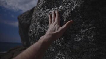 A person is touching a large rock with their hand video