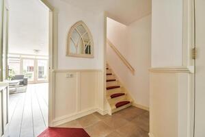A hallway with a red carpet and white walls photo