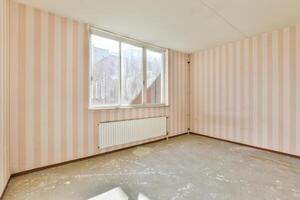An empty room with pink striped walls and a window photo