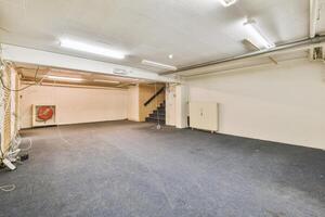 An empty room with a blue carpet and a staircase photo