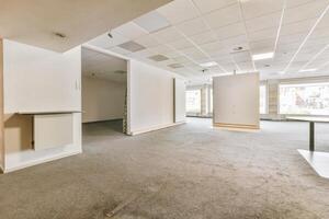 An empty office with a large window and a desk photo
