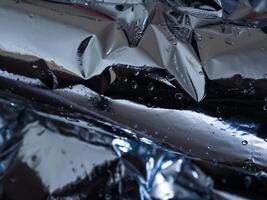 Silver plastic texture in the dark for a mysterious abstract background. photo