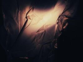 Dark brown plastic bag in lights at night for background about environmental issues. photo