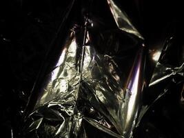 Silver foil in the dark for a mysterious abstract background. photo