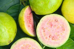 Fresh ripe guava and sliced, sliced guava on wooden table with natural background photo