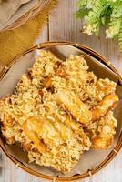 Pisang goreng Coklat Keju is a fritter made by deep frying battered plantain in hot oil. The batter most commonly uses a combination of flour, either wheat, rice flour, tapioca or bread crumb. photo