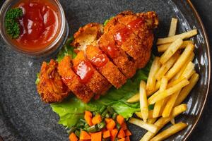 A chicken cordon bleu or schnitzel cordon bleu is a dish of meat wrapped around cheese, then breaded and pan-fried or deep fried. photo