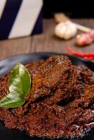 Beef Rendang is a Minang dish originating from the Minangkabau region in West Sumatra, Indonesia. Rendang has been slow cooked and braised in a coconut milk seasoned with a herb and spice mixture photo