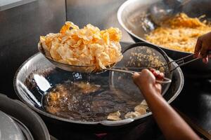 making process Emping Balado, Spicy Snacks from West Sumatra. Made from melinjo crackers, it's crunchy and sweet and spicy. photo