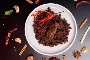 Beef Rendang is a Minang dish originating from the Minangkabau region in West Sumatra, Indonesia. Rendang has been slow cooked and braised in a coconut milk seasoned with a herb and spice mixture photo