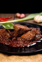 Beef Rendang is a Minang dish originating from the Minangkabau region in West Sumatra, Indonesia. Rendang has been slow cooked and braised in a coconut milk seasoned with a herb and spice mixture photo