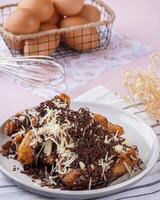 Pisang goreng Coklat Keju is a fritter made by deep frying battered plantain in hot oil. The batter most commonly uses a combination of flour, either wheat, rice flour, tapioca or bread crumb. photo
