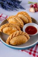 Curry puff or Pastel goreng. it is a small pie consisting of curry with chicken and potatoes in a deep fried or baked pastry shell photo
