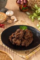 Beef Rendang is a Minang dish originating from the Minangkabau region in West Sumatra, Indonesia. Rendang has been slow cooked and braised in a coconut milk seasoned with a herb and spice mixture photo