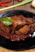 Beef Rendang is a Minang dish originating from the Minangkabau region in West Sumatra, Indonesia. Rendang has been slow cooked and braised in a coconut milk seasoned with a herb and spice mixture photo